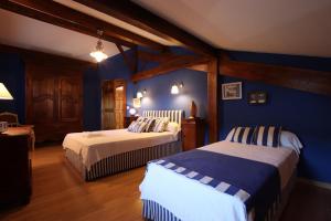 two beds in a room with blue walls at Martirenia in Ossès