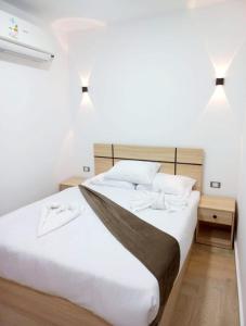 a bedroom with a large white bed with two night stands at Malak Guest House in Cairo +116 photos