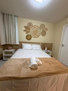 a bedroom with a bed with a towel on it at Iloa resort AP luxo in Barra de São Miguel +34 photos
