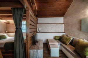 a bedroom with a couch and a bed in a room at Casa Edera by Quokka 360 - Romantic Wooden House in Solduno