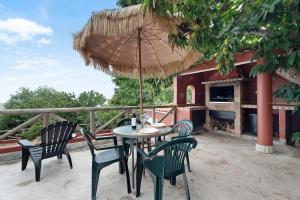 un patio con tavolo, sedie e ombrellone di Los Nardos a Montijos