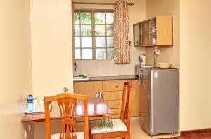 a kitchen with a table and chairs and a refrigerator at Pinetree Gardens Residence in Eldoret