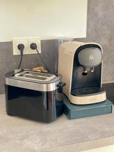 una macchinetta del caffè seduta su un bancone accanto a un tostapane di Les Halles d'Isa et Thomas a Narbonne