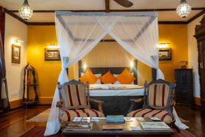 a bedroom with a bed with two chairs and a table at Jafferji House in Zanzibar City