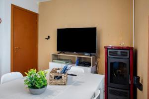 a living room with a flat screen tv and a table with a television at La Terrazza Panoramica in San Sebastiano