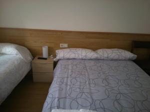 1 dormitorio con cama y cabecero de madera en Hostal L'Esquella, en Aiguafreda