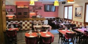 un restaurante con mesas y sillas en una habitación en Hostal L'Esquella, en Aiguafreda