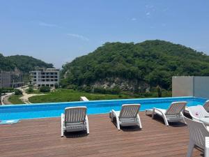 eine Gruppe von Stühlen auf einer Terrasse neben einem Pool in der Unterkunft Costta C305 - Santa Cruz in Santa Cruz Huatulco