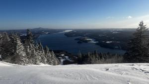 un pendio innevato con vista su un lago di Chalet Bleu Ski In Ski Out With Spa a Mansonville Altre 8 foto