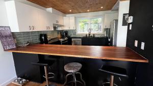 una cucina con piano di lavoro in legno di Chalet Bleu Ski In Ski Out With Spa a Mansonville