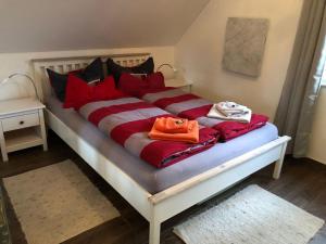 a bed with red pillows and a purse on it at Ferienhaus Karola in Kölpinsee
