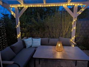 a patio with a couch and a table with lights at Ferienhaus Karola in Kölpinsee +53 photos
