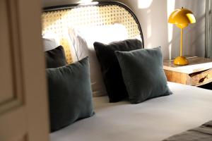 una camera da letto con letto, cuscini e specchio di Maison Sumiane a Brignoles