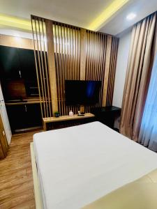 シビウにあるBalcescu Loftの白いベッドと薄型テレビのある寝室