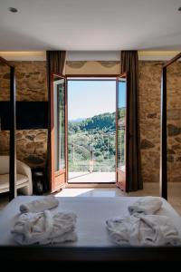 a bedroom with a bed and a large window at LA CASA DEL PANTANO in La Vall de Laguar