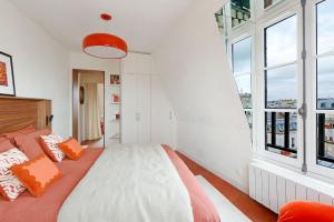 a bedroom with a bed with orange and white pillows at la suite rouge du marais in Paris +16 photos
