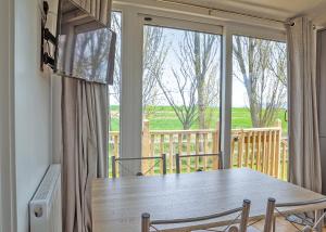 a dining room table with chairs and a large window at Cleveland Hills View Holiday Park in Middleton upon Leven +70 photos