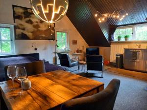 a living room with a wooden table and chairs at Het geheim van Merselo in Merselo