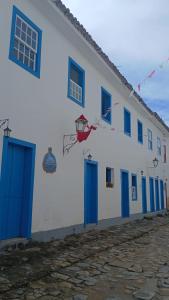 a white building with blue doors and a basketball hoop on it at Pousada Santa Rita in Paraty