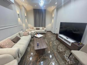 Una sala de estar con un sofá y un televisor grande. en Grand Luxury Apartments - Downtown Cairo, en El Cairo 21 fotos más