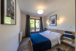 a bedroom with a large bed and a window at Le Bord Du Nant in Arâches-la-Frasse