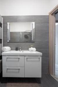 a bathroom with a white sink and a mirror at Rocca Lake House in Angera