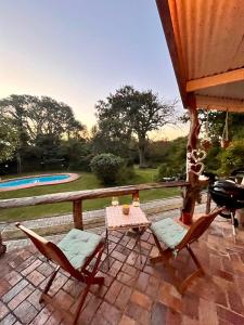un patio con sillas, una mesa y una parrilla en Gorgeous home - 5 minutes from Grahamstown, en Grahamstown