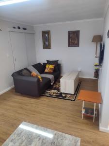 una sala de estar con un sofá y una mesa en Birds Holiday Accommodation 1, en Zeekoevlei