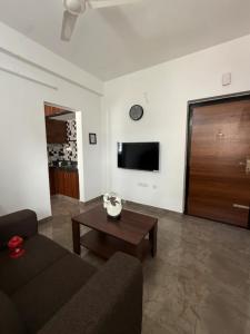 a living room with a couch and a table at The Cozy Cranny in Chennai