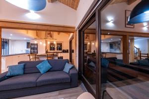 a living room with a couch and a kitchen at Le Bord Du Nant in Arâches-la-Frasse