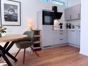 Una cocina con una mesa y un comedor. en Kraanstiet 3, en Zingst 23 fotos más