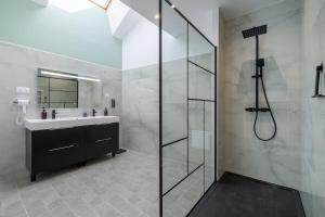 Un baño con ducha de cristal y lavabo. en La Terrasse - Wifi - Parking - Clim, en Laval