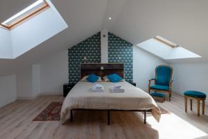 Un dormitorio con una cama y una silla azul. en La Terrasse - Wifi - Parking - Clim, en Laval