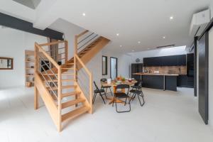 cocina y comedor con escalera de madera y mesa en La Terrasse - Wifi - Parking - Clim, en Laval