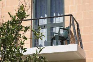 a balcony with a chair in a window at Rivotorto Retreat House in Birkirkara