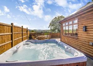 bañera de hidromasaje en el patio de una casa en Heart Of Wales Lodges, en Penybont 36 fotos más