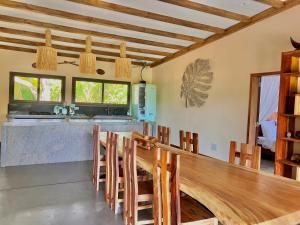 a kitchen with a long wooden counter and chairs at Villas Kokoa Serena in Sainte Marie