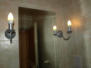 a bathroom with two lights and a mirror at Rivotorto Retreat House in Birkirkara