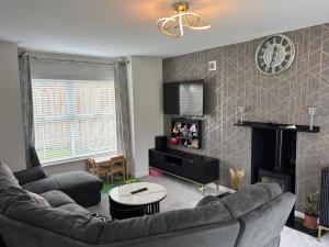 Una sala de estar con un sofá y una chimenea. en ADI Holiday Home Lurgan, en Lurgan