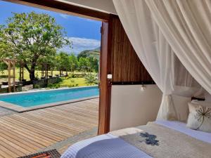 a bedroom with a bed and a view of a pool at Villas Kokoa Serena in Sainte Marie