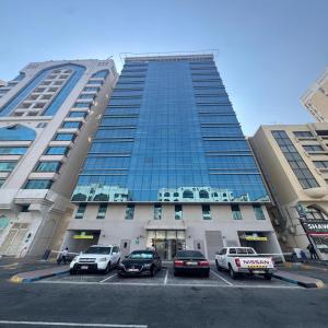 a large building with cars parked in a parking lot at Premier 2-bedroom Lifeline apartment with free Parking in Abu Dhabi