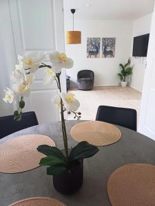 a table with a vase with white flowers on it at Charming 2 bedroom apartment free parking in Hjørring