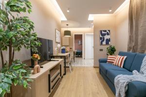 Una sala de estar con un sofá azul y un televisor en Sagrada Familia Xamfrà, en Barcelona