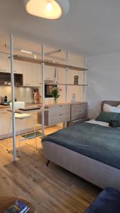 Un dormitorio con una cama y un escritorio y una cocina. en Modern Living - Neubau-Studio mit Stil, en Lörrach