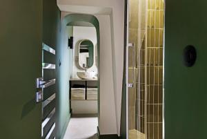 a bathroom with a sink and a mirror at la suite verte du marais in Paris