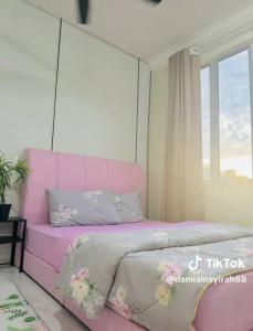 a pink bed in a room with a window at CUTE Homestay in Tumpat