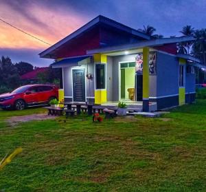 a small house with a car parked in front of it at CUTE Homestay in Tumpat