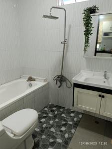 a bathroom with a toilet and a tub and a sink at CUTE Homestay in Tumpat