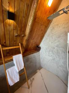an attic room with a wooden ceiling and a chair at DChalé in Japaratinga +27 photos