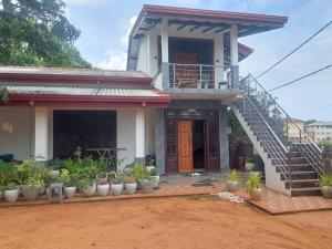 a house with a staircase and plants in front of it at Hostel Lali beach villa in Trincomalee